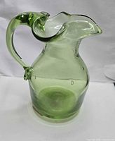 full view showing pitcher shape and green glass
