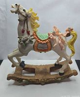 left side view of resin rocking horse on rocker base
