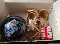 Boxed assortment showing Super Mario Galaxy bauble, wicker items, folded star, fabric present
