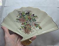 Front view displaying floral design, color, gold trim and fan shape