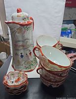 Group shot showing pitcher, stacked cups, stacked scalloped dishes