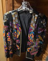 Front view of embellished velvet jacket on hanger