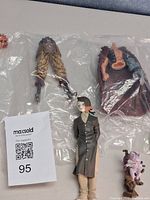 Overview showing all figure parts, assembled figure, accessory, and small creature