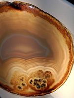 close view of large polished agate slice showing banding and druzy pocket