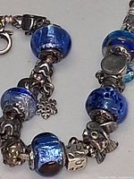 Close-up of bracelet showing blue glass beads, 925 silver spacers and charms