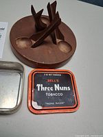 Round wood stand with four rests, tin base and lid