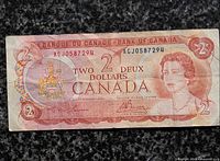 Front view of 1974 Canadian $2 bill showing serial AGJ0587294, portrait, coat of arms and wear