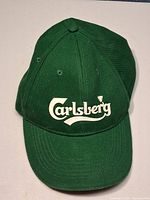 Front view of green Carlsberg baseball cap