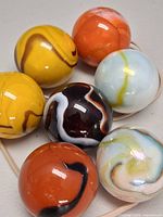 Seven assorted swirl glass marbles close-up view