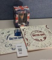 Front view of boxed Sherlock vinyl figure with two Doctor Who colouring books