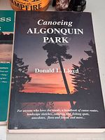 Front cover Canoeing Algonquin Park book with partial view of mug and flashlight