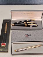 Overview showing Marlboro boxed pen, Cathay Pacific case with two pens, Quill boxed pen