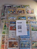 Stack of binder pages filled with Pokémon cards; shows quantity and storage method
