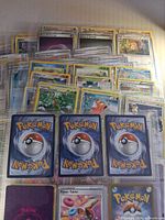 Stack of sleeved Pokémon cards showing variety of sets and card backs