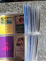 Stack of filled nine-pocket binder pages viewed from the side showing quantity of pages and sleeved cards