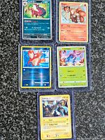 Front view of five sleeved Pokémon cards