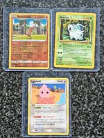 Three English Pokémon cards in toploaders: Sudowoodo, Nidoran♀, Igglybuff