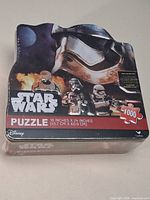 Shrink-wrapped Star Wars puzzle tin front view with characters and size info