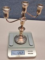 Full candelabra on digital scale reading 592 g