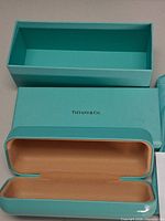 Open Tiffany Blue outer box base and lid, open hard shell case showing tan interior