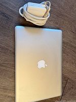 Closed MacBook Pro top view with Apple logo and coiled MagSafe adapter