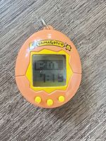 Front view showing screen, buttons, logo and keychain loop