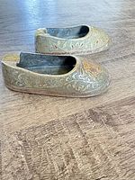 Both brass shoe-shaped ashtrays side view