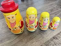 Four yellow nesting dolls in descending size order