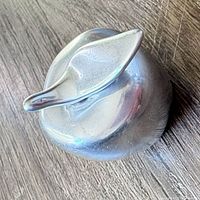 Top view of polished metal apple with leaf