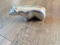 Side view of polished aluminum abstract bear sculpture