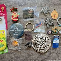 Overview of mixed pins, keychains, brooches and ornaments on wood surface