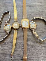 All four wristwatches side by side showing overall condition and bracelets