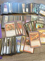 Stacks of Magic: The Gathering cards, various colors and some sleeved
