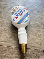 Front view of Molson Canadian ceramic tap handle showing branding and brass base