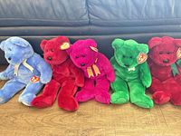 Row of five coloured bears seated (blue, red, magenta, green, red) showing colours, ribbons, tags