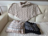 Overview of three knit garments on sofa