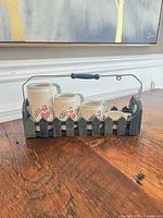 Front view of four ceramic measuring cups in wooden carrier