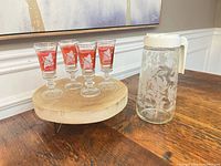 Cordial glasses and pitcher grouped on wooden surface showing overall condition and designs