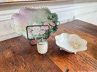 Group shot showing floral porcelain tray, milk glass shaker with crank, and footed porcelain compote
