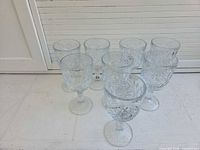 Eight clear pressed glass goblets grouped together