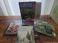 Five hardcover books arranged on table showing titles