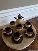 Full view of the miniature tea set on wooden base