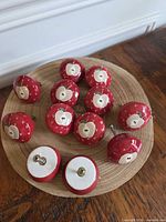 Group of red apple ceramic knobs on wooden surface