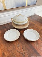 overview of tureen on riser with two plates displayed
