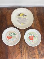 All three ceramic plates shown: lemon pie plate, cherry plate, apple plate