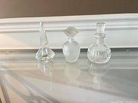 Front view of three perfume bottles with stoppers