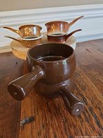 Front view of two brown handled ramekins showing shape and glaze finish