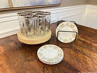 Overall view of six tumblers on stand and six plates on rack