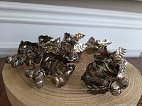 Group view of all eight silver-tone holly leaf napkin rings with bells