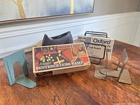 Lot overview showing Scrabble box, sealed index cards on wire stand, tape dispenser, two metal bookends